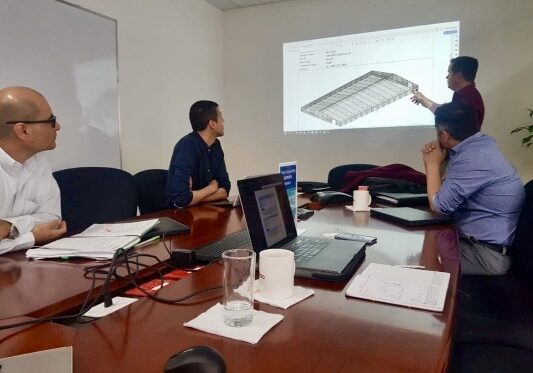 Allied Steel Buildings employees in the office holding presentations of client projects and concepts